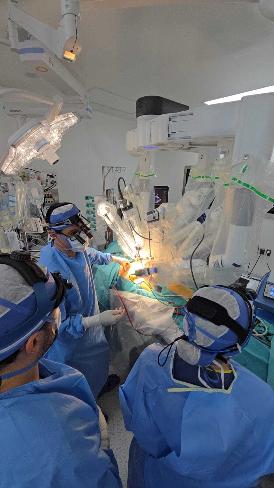Equipo quirúrgico completo trabajando en conjunto durante una cirugía robótica cardíaca